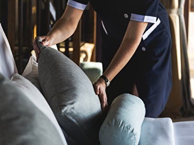 Housekeeping lady puts the pillow right in the hotel room